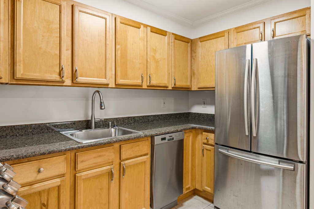 118-82 Metropolitan Avenue, Unit 3A Queens, NY 11415 - Photo 10 of 19 a kitchen with stainless steel appliances granite countertop a refrigerator and a sink