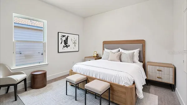 a bedroom with a bed a table and a window