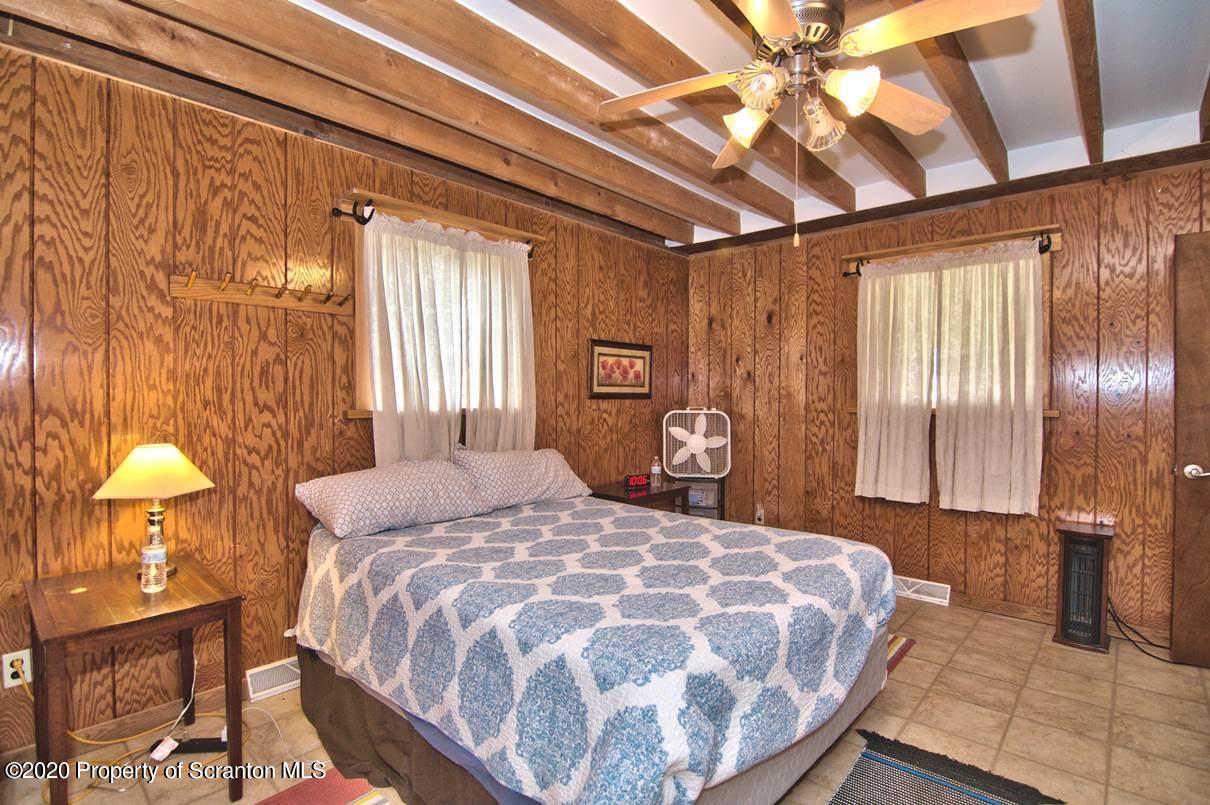 293 State Rte 1002 Tunkhannock, PA 18657 - Photo 16 of 71 a bedroom with a bed and a chandelier