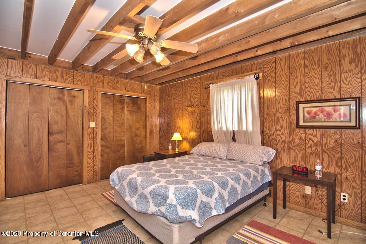 293 State Rte 1002 Tunkhannock, PA 18657 - Photo 17 of 71 a bedroom with a bed and a chandelier