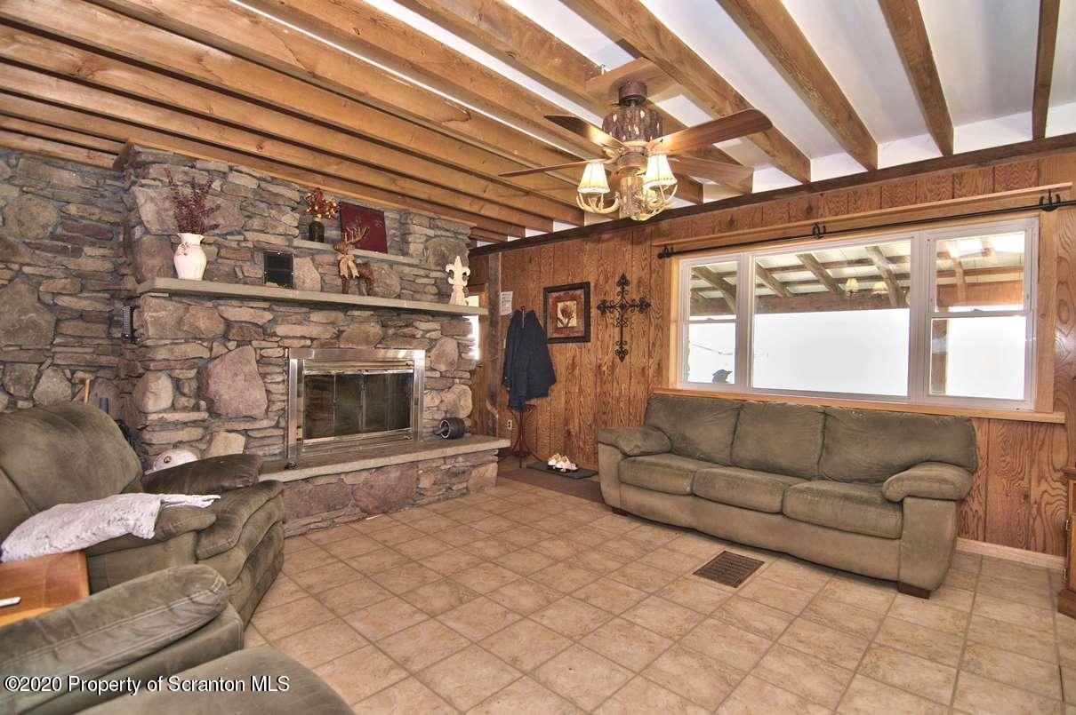 293 State Rte 1002 Tunkhannock, PA 18657 - Photo 7 of 71 a living room with furniture a fireplace and a floor to ceiling window