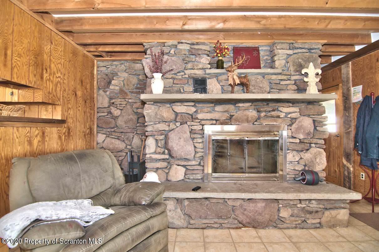 293 State Rte 1002 Tunkhannock, PA 18657 - Photo 8 of 71 a living room with furniture and a fireplace