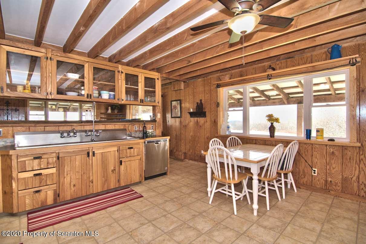 293 State Rte 1002 Tunkhannock, PA 18657 - Photo 10 of 71 a dining hall with stainless steel appliances granite countertop a stove a sink and a dining table with wooden floor