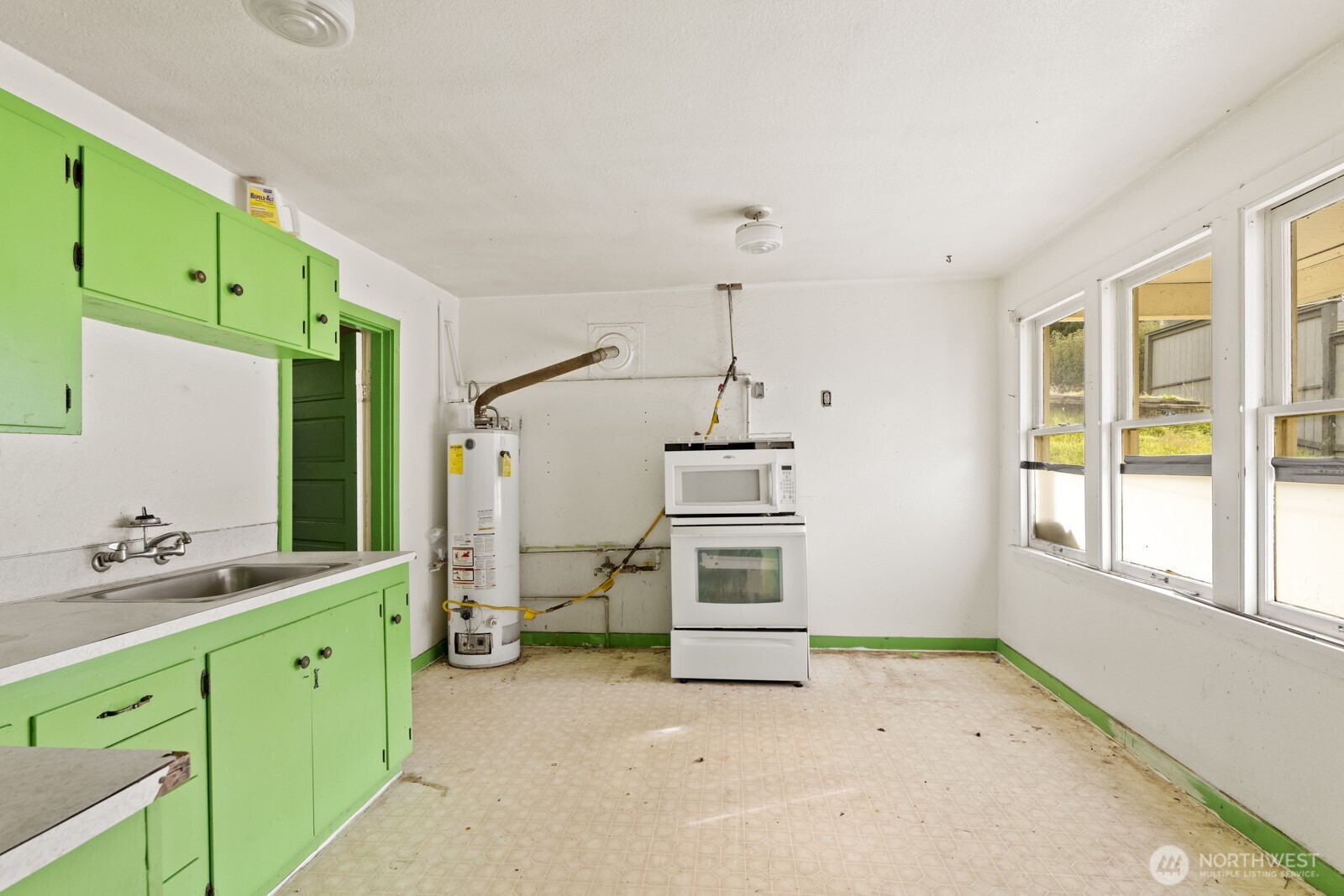 4812 46th Avenue Southwest Seattle, WA 98116 - Photo 21 of 26 a utility room with cabinets a sink and a window