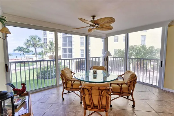 a dining room with furniture a chandelier and glass door