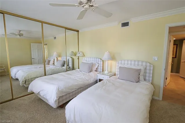 a bedroom with two beds and a chandelier