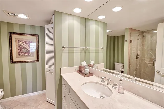 a bathroom with a granite countertop sink a mirror a shower and a bathtub