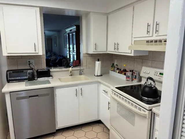 a kitchen with white cabinets sink and white appliances