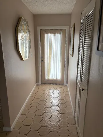 a view of an empty room with wooden floor and windows