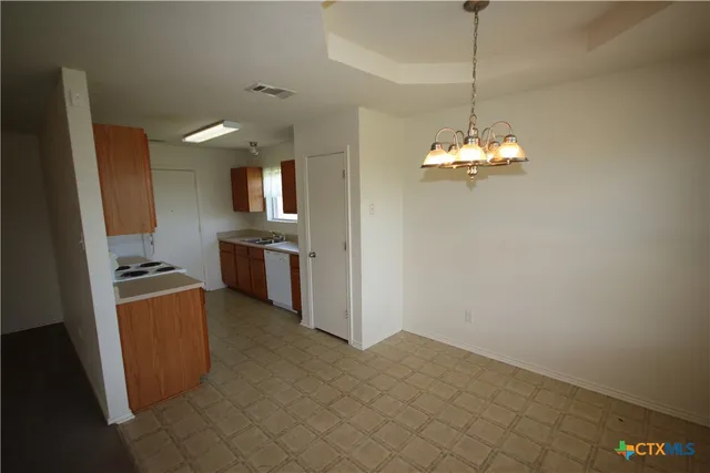 a kitchen with granite countertop a refrigerator and a stove