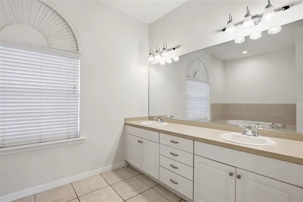 a spacious bathroom with a granite countertop sink a mirror and a vanity