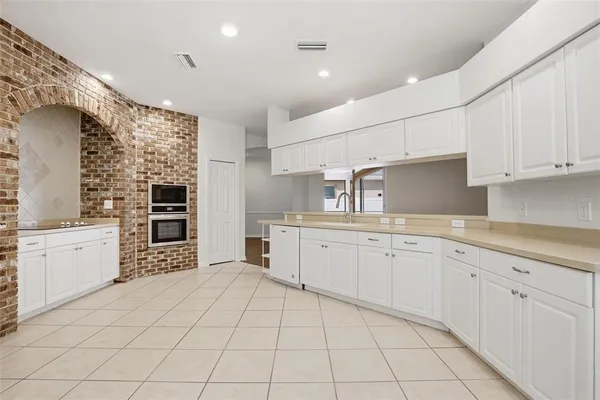 a large white kitchen with cabinets