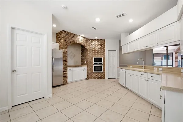 a kitchen with white cabinets and white appliances