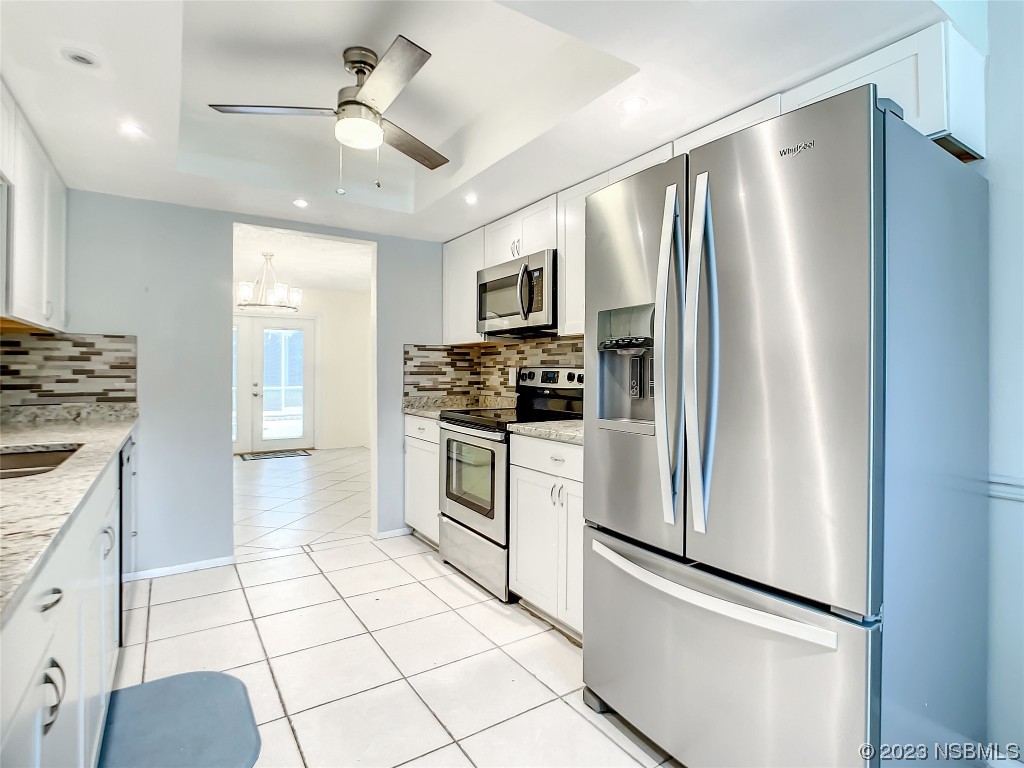 865 North Ridgewood Avenue Ormond Beach, FL 32174 - Photo 19 of 32 a kitchen with stainless steel appliances a refrigerator sink and stove top oven