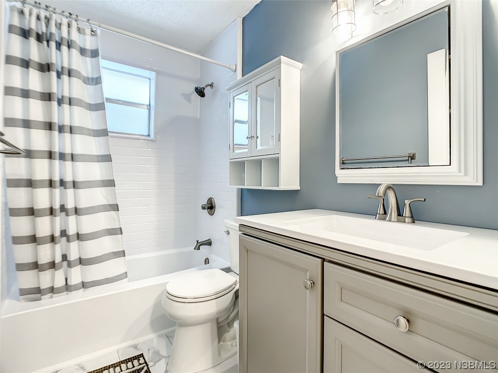 865 North Ridgewood Avenue Ormond Beach, FL 32174 - Photo 24 of 32 a bathroom with a granite countertop sink toilet a mirror a vanity and shower