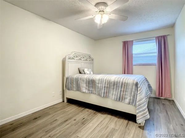an empty room with wooden floor cabinet and windows