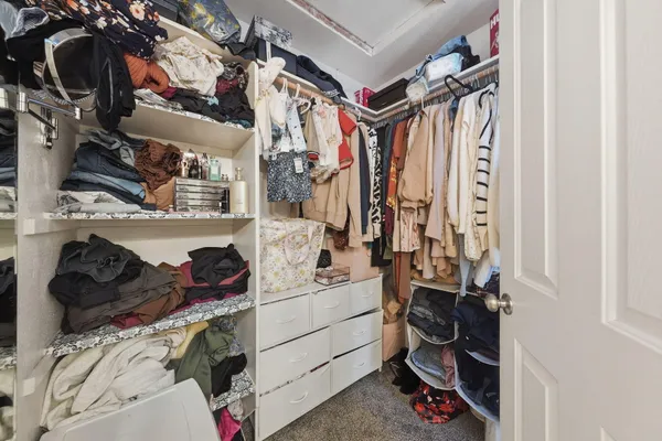 a view of walk in closet with clothes and shoes
