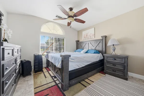 a bedroom with a large bed and a ceiling fan