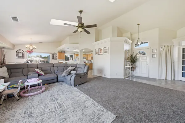 a living room with furniture and a ceiling fan