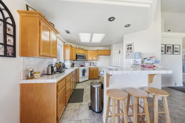 a kitchen that has a sink and chairs