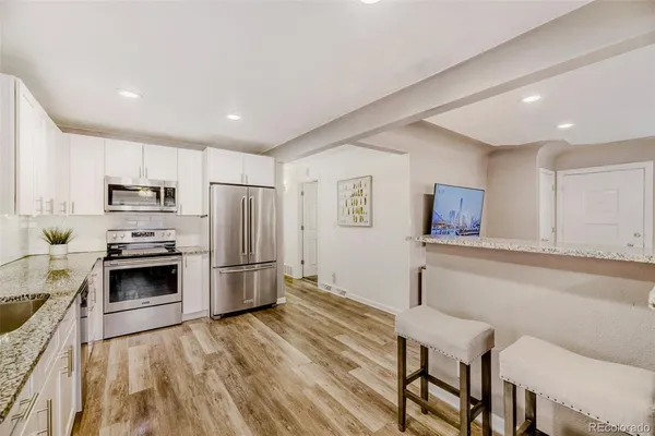 a kitchen with cabinets and wooden floor