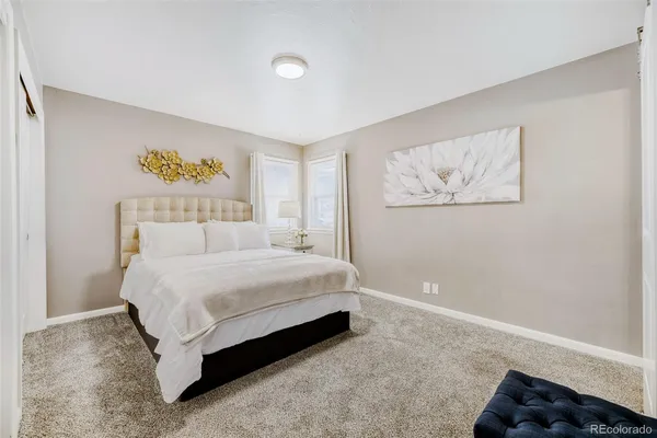 a spacious bedroom with a bed and wall painting
