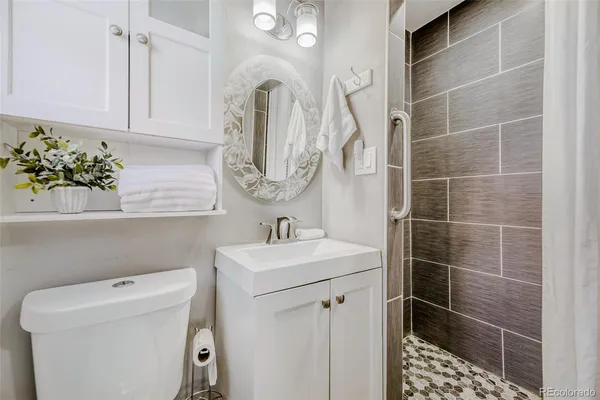 a bathroom with a sink a toilet and a mirror