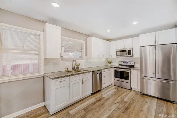 a kitchen with cabinets stainless steel appliances a sink and a window