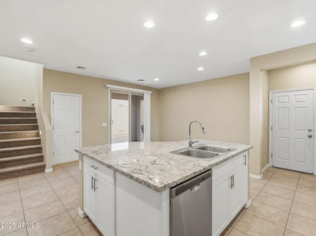 a kitchen with stainless steel appliances granite countertop a sink stove and cabinets