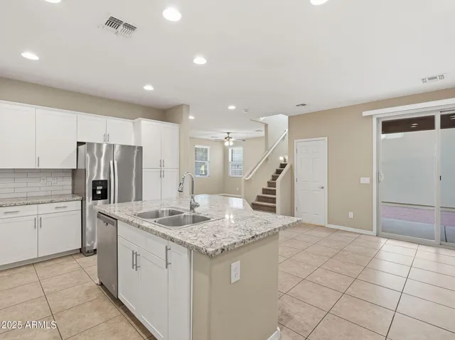 a hall with kitchen island a sink granite counter tops and a stove