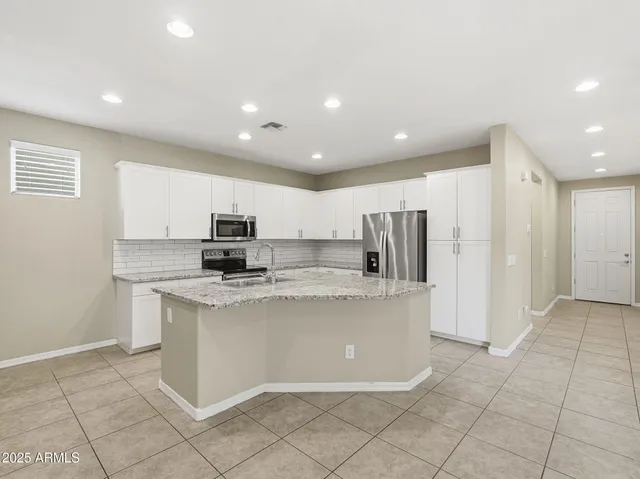 a kitchen with refrigerator and microwave