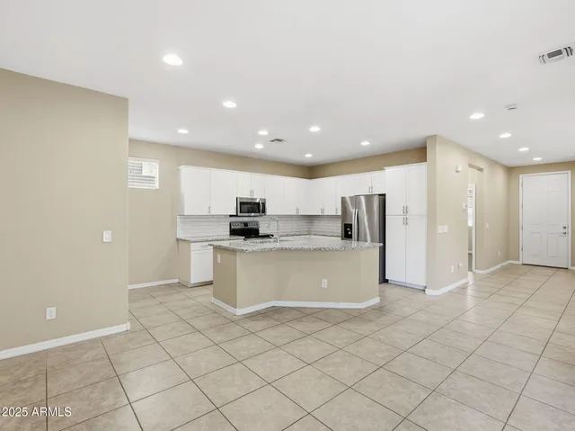 a view of kitchen with stainless steel appliances granite countertop a stove and a sink