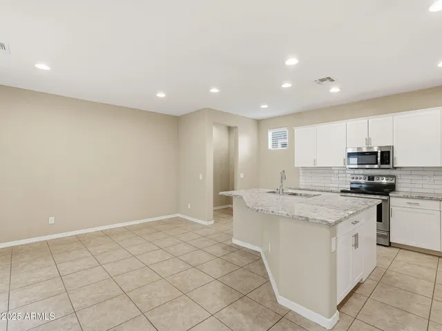 a view of kitchen with stainless steel appliances a refrigerator and a stove top oven