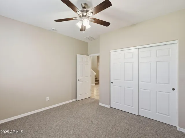 an empty room with a window and a fan