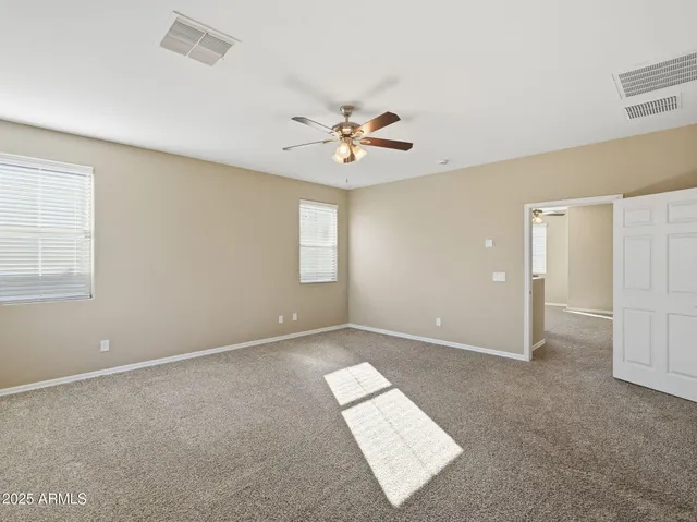 wooden floor in an empty room with a ceiling fan