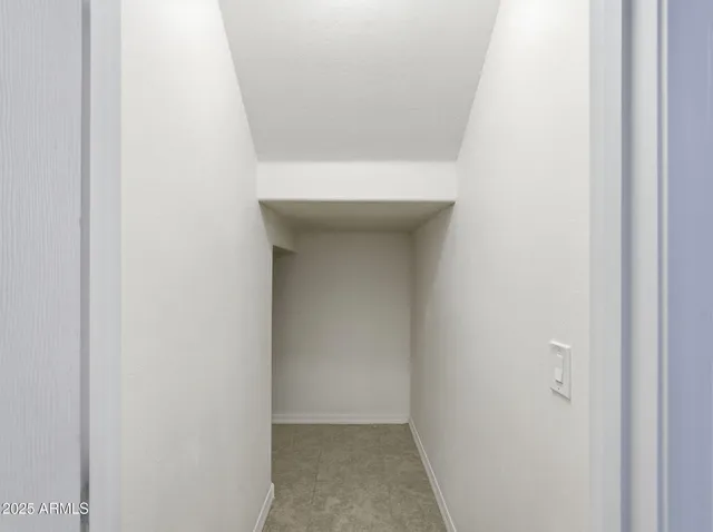 an empty room with a white wall & dryer
