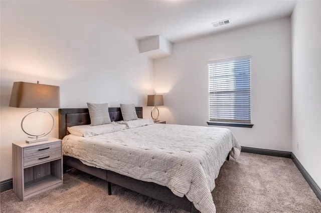 a bedroom with a bed a window and a chandelier