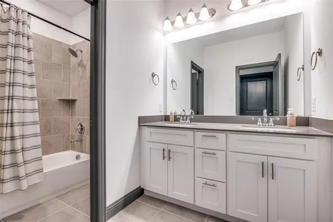 a en suite bathroom with a double vanity sink and a mirror