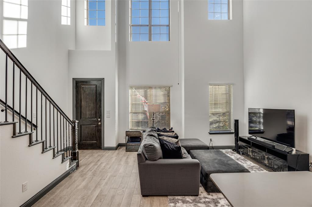 8132 Foraker Street Frisco, TX 75034 - Photo 4 of 25 Living room featuring plenty of natural light, light wood-style floors, stairs, and a towering ceiling