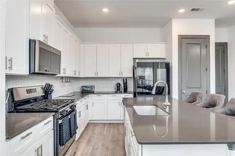 a kitchen with stove a sink and refrigerator