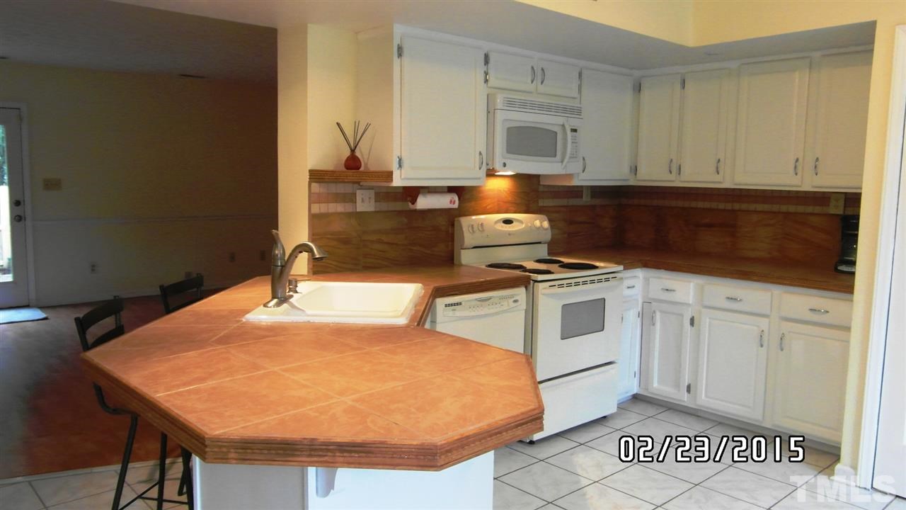 8184 McGuire Drive Raleigh, NC 27616 - Photo 4 of 23 a kitchen with granite countertop a stove a sink and a microwave
