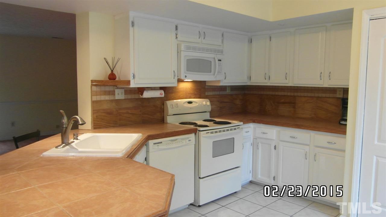 8184 McGuire Drive Raleigh, NC 27616 - Photo 8 of 23 a kitchen with granite countertop white cabinets and white appliances