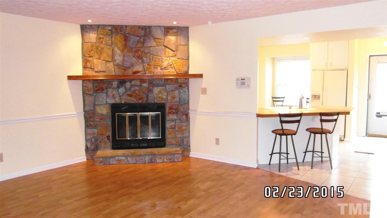 8184 McGuire Drive Raleigh, NC 27616 - Photo 10 of 23 a living room with a furniture a fireplace and a floor to ceiling window