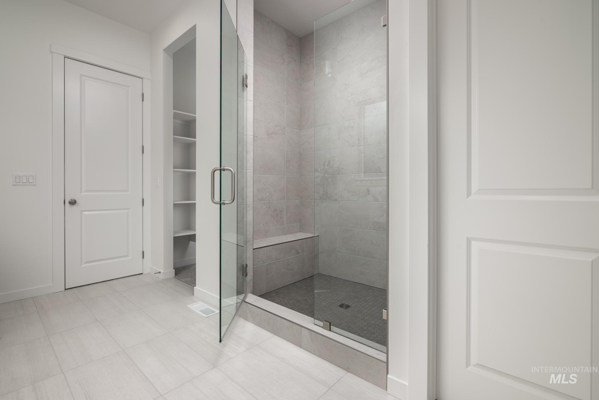 5402 Juliet Rose Avenue Caldwell, ID 83607 - Photo 10 of 20 Glass-enclosed shower with a built-in bench, tiled walls, and a tiled shower pan