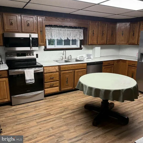 a kitchen with a sink cabinets stainless steel appliances and a counter space
