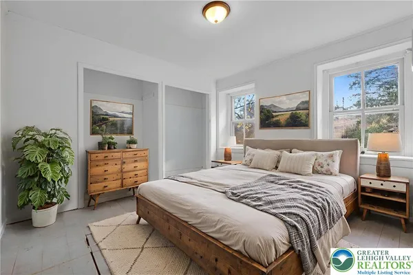 a bedroom with a bed and a dresser next to a window