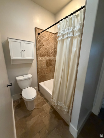 4536 North 475 East Provo, UT 84604 - Photo 25 of 65 Bathroom featuring a built-in bathtub with a tiled surround, a wall-mounted cabinet, and large format stone-finish floor tiling