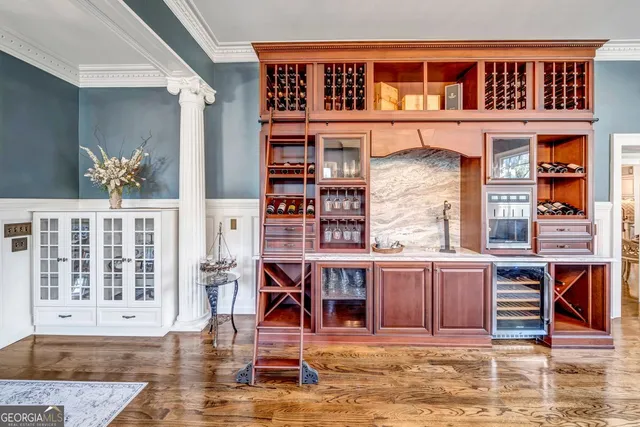 a dining room with wooden floor a chandelier a wooden table and chairs