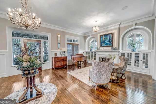 a living room with furniture a chandelier and a fireplace