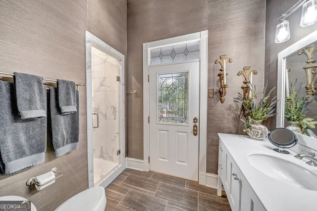 a view of a patio with couches table and chairs with wooden fence and plants